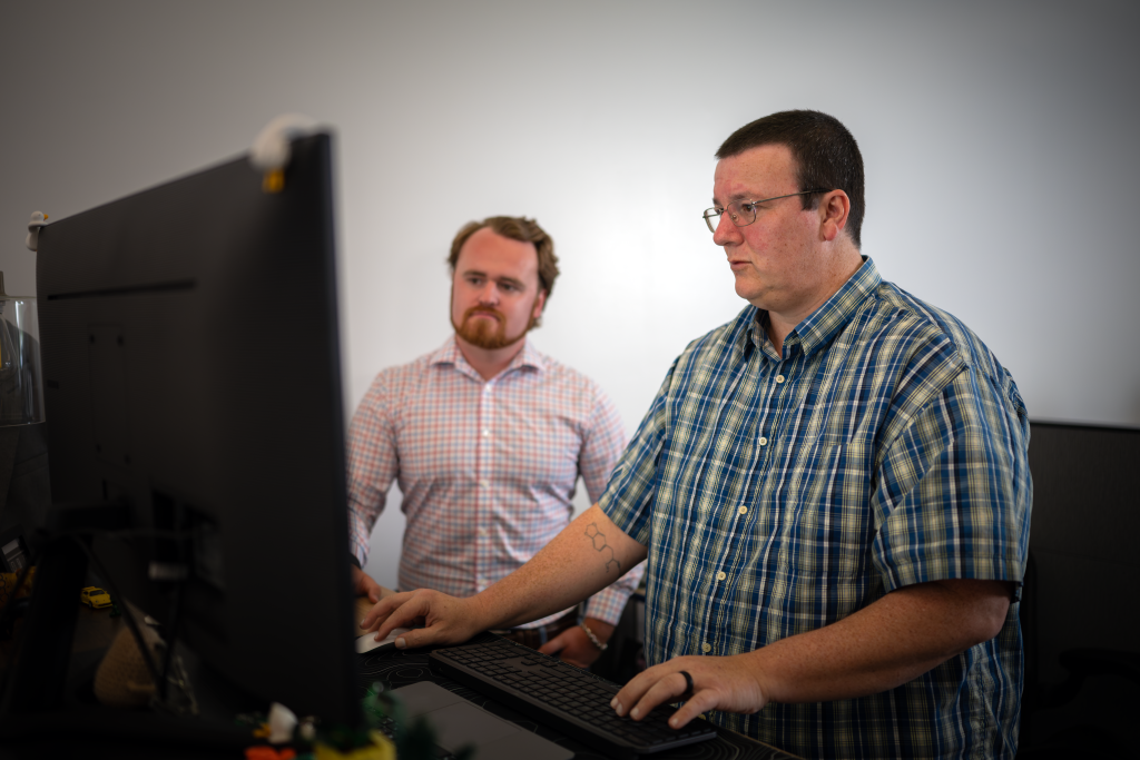Two employees working on a project at a desk
