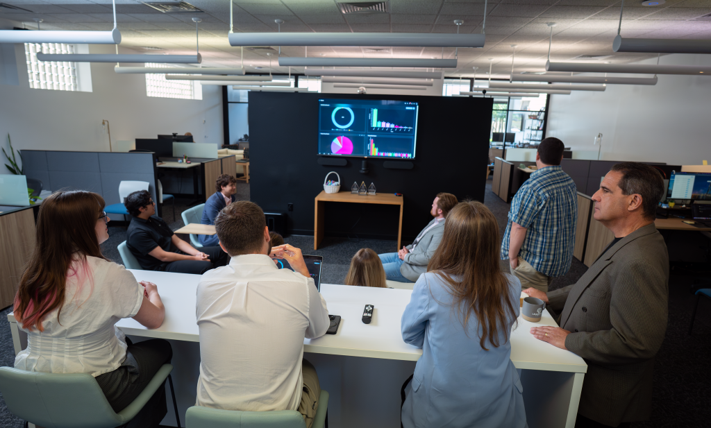 Team gathered and discussing a data dashboard.