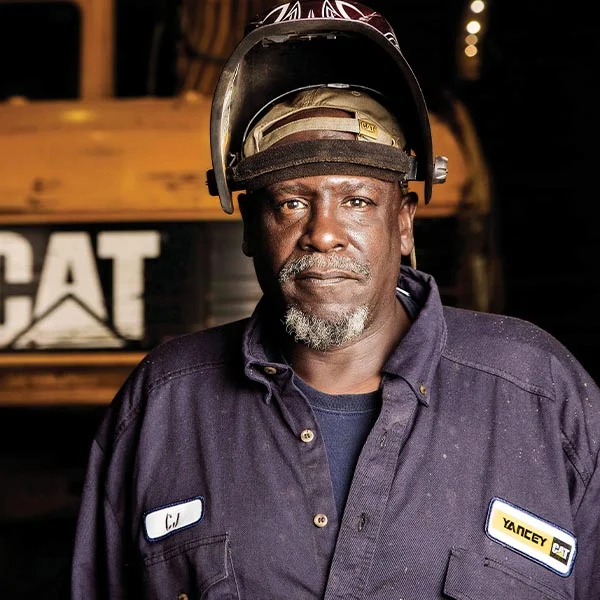 yancey employee standing in front of heavy machinery